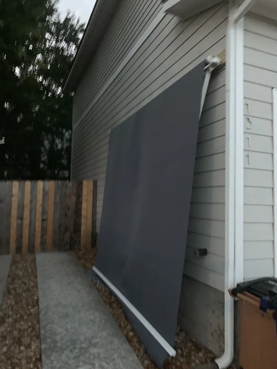 Added side awning on an East Austin house exterior with siding, downspout, and side-yard access