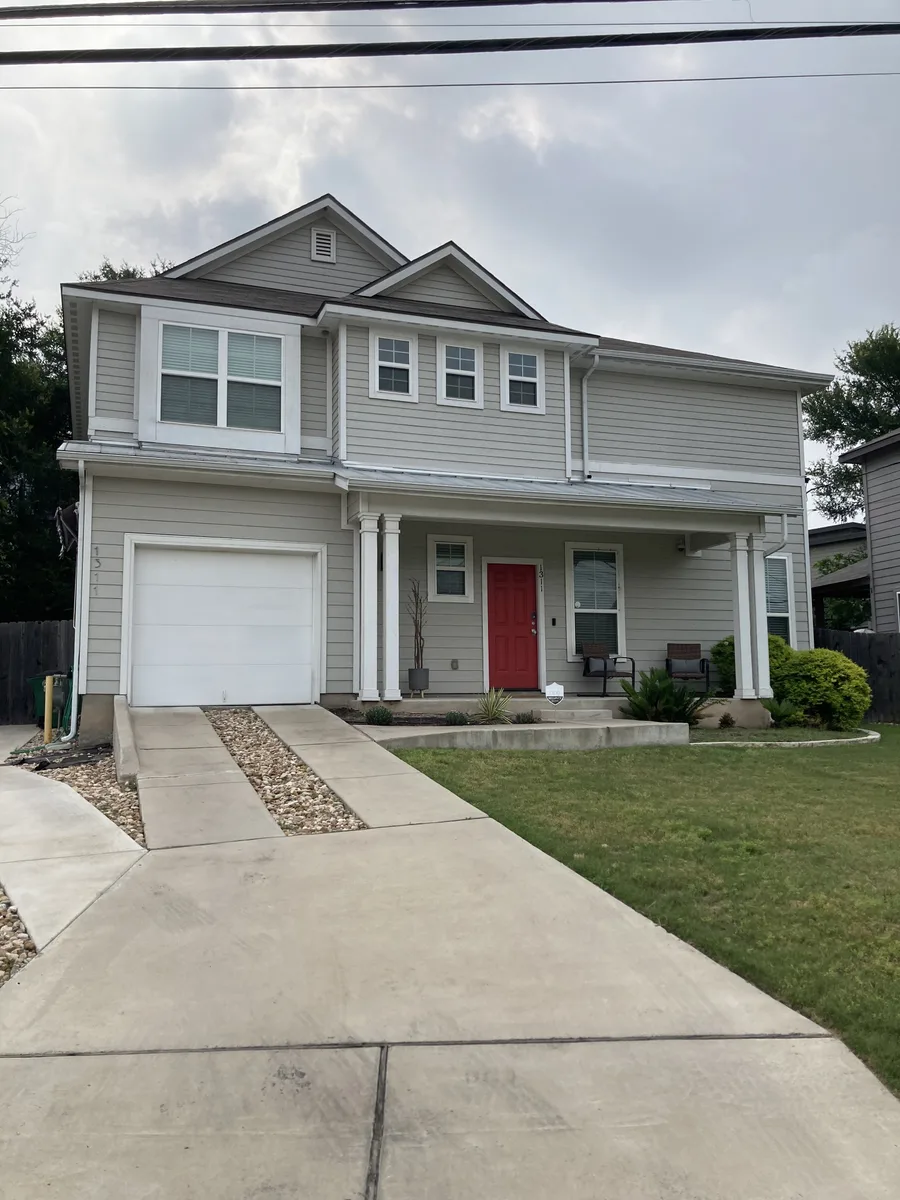 East Austin house exterior with siding, trim, garage, front door, and finished front elevation
