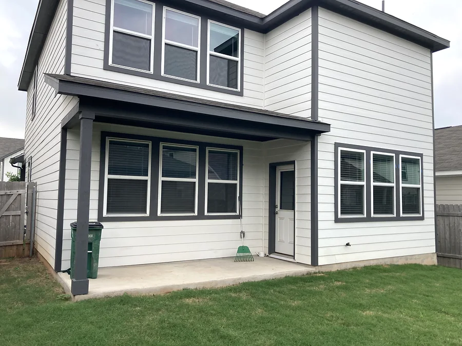 Side and rear view of Pflugerville house exterior painting with light siding and dark trim